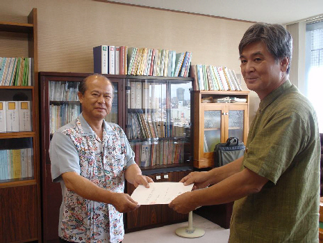 仲田沖縄県土木建築部長から同意書を受け取る島袋うるま市長